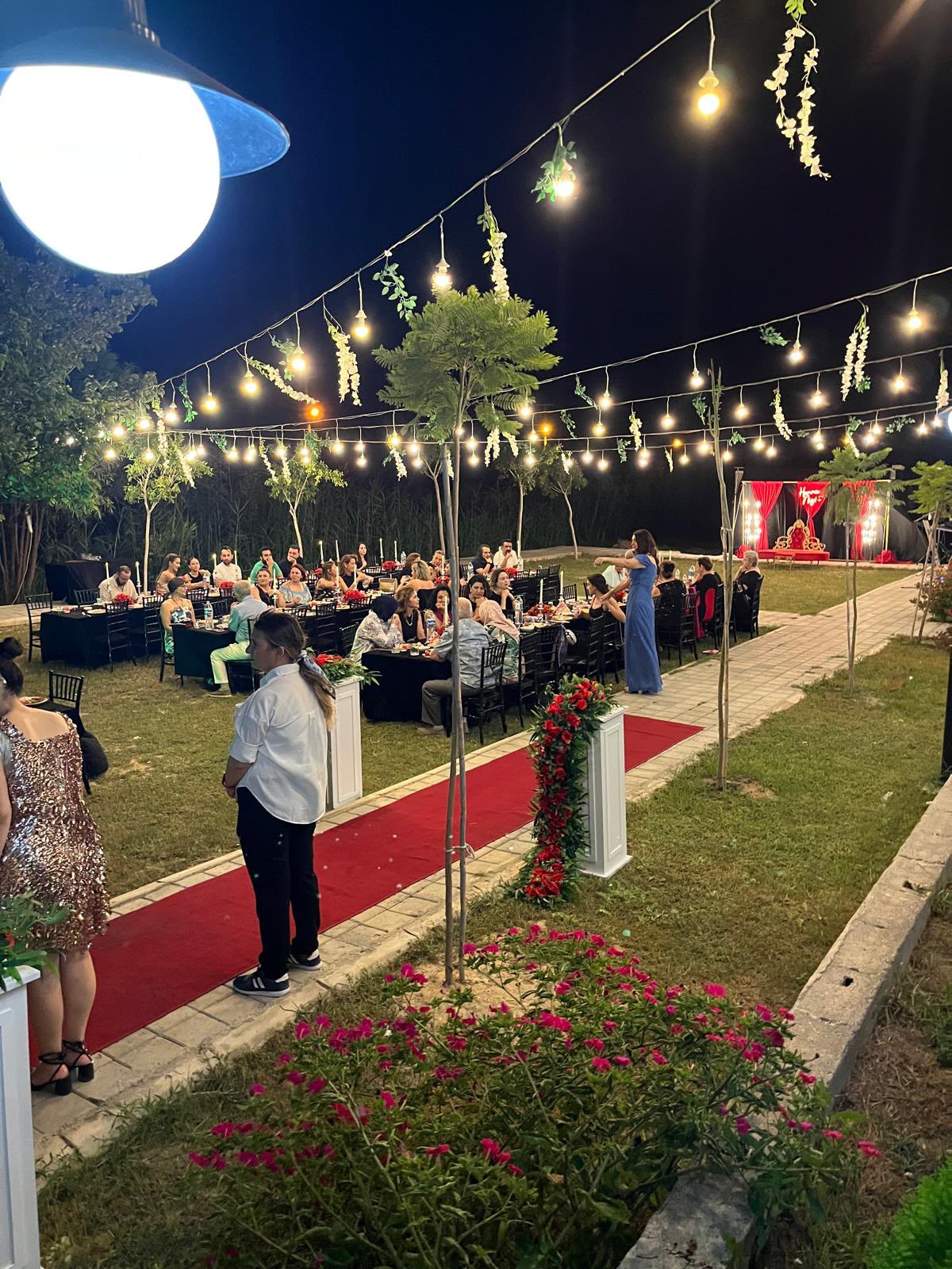 Işıklarla süslenmiş otel bahçesinde akşam daveti